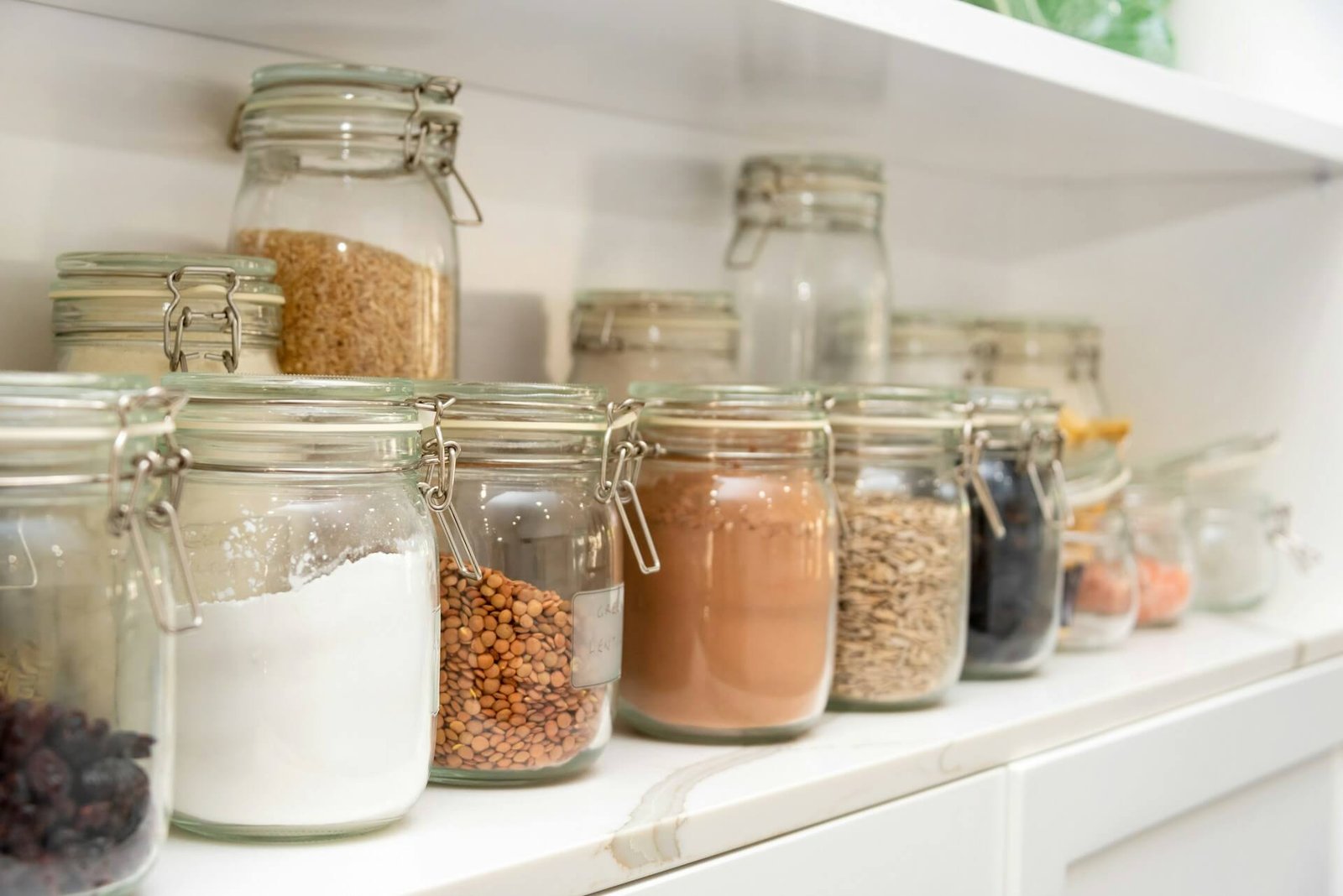 Gut health kitchen staples: cupboard shelves with jars of pulses and grains